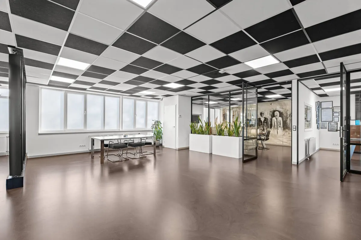 Loftkantoor met zwart plafond en lange tafel