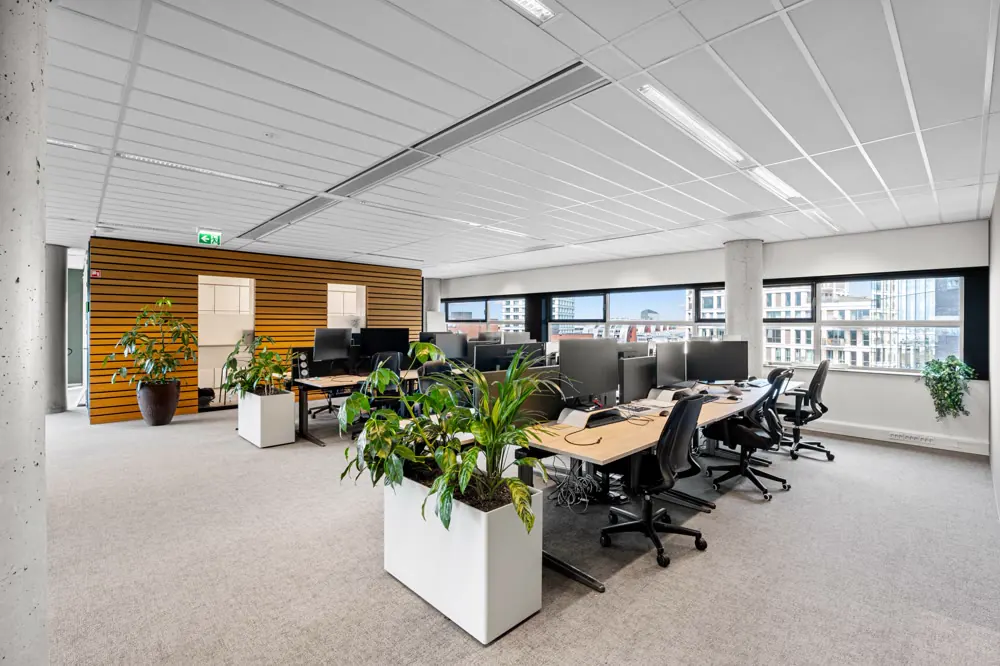 Kantoortuin met werkplekken en planten