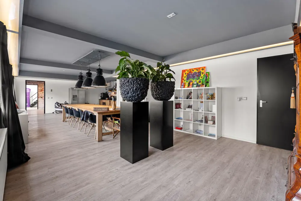 Open kantoorruimte met hoog plafond en planten